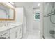 Bright bathroom featuring white cabinets, marble floors, and a glass enclosed shower at 3612 Bill Gardner Pkwy, Locust Grove, GA 30248