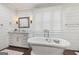 Bathroom featuring shiplap walls, free standing tub, and white vanity at 3612 Bill Gardner Pkwy, Locust Grove, GA 30248