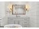 Bright bathroom featuring white shiplap walls, marble countertop, and a rustic framed mirror at 3612 Bill Gardner Pkwy, Locust Grove, GA 30248