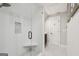 Elegant white bathroom featuring a walk-in shower with glass door and white penny tile floor at 3612 Bill Gardner Pkwy, Locust Grove, GA 30248