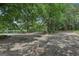 Gravel driveway leading through mature trees, offering a private and inviting entrance at 3612 Bill Gardner Pkwy, Locust Grove, GA 30248