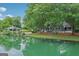 Picturesque view of a lakeside home with lush greenery, offering serene outdoor living and beautiful reflections at 3612 Bill Gardner Pkwy, Locust Grove, GA 30248