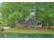 Charming lakeside home with a fire pit and inviting outdoor seating areas amidst mature trees and landscaping at 3612 Bill Gardner Pkwy, Locust Grove, GA 30248