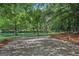 Gravel lot nestled amidst trees, presenting a serene setting with lake access at 3612 Bill Gardner Pkwy, Locust Grove, GA 30248