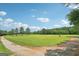 Expansive green field under a blue sky, offering endless possibilities for outdoor activities at 3612 Bill Gardner Pkwy, Locust Grove, GA 30248