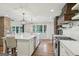 Bright, open kitchen with large island, stainless appliances, farmhouse sink and hardwood floors at 3612 Bill Gardner Pkwy, Locust Grove, GA 30248
