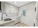 Bright laundry room with gray cabinets, quartz countertops, and a door to the backyard at 3612 Bill Gardner Pkwy, Locust Grove, GA 30248