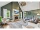 Cozy living room featuring a brick fireplace, decorative ceiling fan, and comfortable seating arrangement at 3612 Bill Gardner Pkwy, Locust Grove, GA 30248