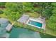 Aerial shot of a private pool with stone patio, lounge chairs, and lake access surrounded by mature trees at 3612 Bill Gardner Pkwy, Locust Grove, GA 30248