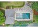 Overhead view of a private backyard pool with a stone patio and lake access surrounded by manicured landscaping at 3612 Bill Gardner Pkwy, Locust Grove, GA 30248