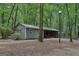 Exterior view of the shed surrounded by lush trees at 3612 Bill Gardner Pkwy, Locust Grove, GA 30248