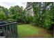 Large backyard featuring a well-maintained lawn surrounded by mature trees at 12043 Olmstead Dr, Fayetteville, GA 30215