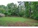 Large grassy backyard with mature trees and partial fence line at 12043 Olmstead Dr, Fayetteville, GA 30215