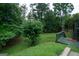 Spacious backyard with lush greenery, a wooden deck, and mature trees, perfect for outdoor enjoyment at 12043 Olmstead Dr, Fayetteville, GA 30215