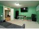 Finished basement features green walls, neutral carpet, and a TV area, ideal for entertainment and relaxation at 12043 Olmstead Dr, Fayetteville, GA 30215