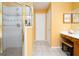 Bright bathroom with a shower, vanity, and tiled floor in an orange color scheme at 12043 Olmstead Dr, Fayetteville, GA 30215