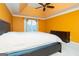 Bedroom featuring a bed, dresser, tray ceiling, and natural light in an orange color scheme at 12043 Olmstead Dr, Fayetteville, GA 30215
