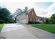 Long concrete driveway leading to a brick and siding home with an attached garage, providing ample parking space at 12043 Olmstead Dr, Fayetteville, GA 30215