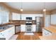 Well-equipped kitchen featuring stainless steel appliances, sleek white cabinetry, and ample counter space at 12043 Olmstead Dr, Fayetteville, GA 30215