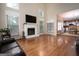 Spacious living room featuring a fireplace, large windows, and hardwood floors with views to the dining area at 12043 Olmstead Dr, Fayetteville, GA 30215