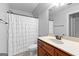 A bathroom with a vanity with dark cabinets and a shower with a white curtain at 360 Grandmas Ln, Fayetteville, GA 30215