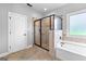 Bathroom with separate neutral tile shower, tub, and a window at 360 Grandmas Ln, Fayetteville, GA 30215