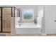 Bathroom with a neutral tile shower, soaking tub, and window at 360 Grandmas Ln, Fayetteville, GA 30215
