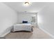 A bright bedroom with carpet, a window, and a bed with blue and white covers at 360 Grandmas Ln, Fayetteville, GA 30215
