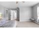 A bright bedroom with carpet, multiple doorways, and a bed with gray covers at 360 Grandmas Ln, Fayetteville, GA 30215