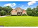 Stunning home exterior with manicured lawn, mature trees, and inviting curb appeal on a sunny day at 360 Grandmas Ln, Fayetteville, GA 30215