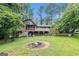 Large backyard with a deck, patio, fire pit, and mature trees at 6230 S Summers Cir, Douglasville, GA 30135