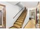 Hallway with carpeted stairs, wood trim, and wall-mounted handrail at 6230 S Summers Cir, Douglasville, GA 30135