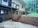 Back exterior view showing brick foundation, patio, and access to deck at 205 Avon Dr, Fayetteville, GA 30215