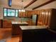Well-lit kitchen featuring wood cabinets, an island sink, stone countertops, and wooden floors at 205 Avon Dr, Fayetteville, GA 30215