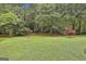 Green backyard featuring mature trees, lawn and border plantings at 107 Jennings Yard, Peachtree City, GA 30269