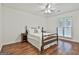 Bedroom with wood floors, wooden bed, and white linens near window at 107 Jennings Yard, Peachtree City, GA 30269