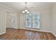 Elegant dining room with hardwood floors, chandelier, and bright window, adjacent to the entrance and kitchen at 107 Jennings Yard, Peachtree City, GA 30269