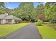 Long driveway leading to a well-maintained home with lush landscaping and a charming exterior at 107 Jennings Yard, Peachtree City, GA 30269