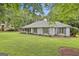 Charming single-story home featuring a covered porch, blue shutters, and well-manicured lawn at 107 Jennings Yard, Peachtree City, GA 30269