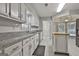 Well-lit kitchen with white cabinets, granite countertops, stainless steel appliances, and access to the breakfast nook at 107 Jennings Yard, Peachtree City, GA 30269