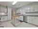 Bright kitchen features white cabinets, stainless steel appliances, gray countertops, and a functional kitchen island at 107 Jennings Yard, Peachtree City, GA 30269