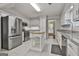 Well-equipped kitchen with stainless steel appliances, white cabinetry, granite countertops, and a convenient center island at 107 Jennings Yard, Peachtree City, GA 30269