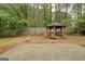 Enjoy the outdoors with this wooden gazebo surrounded by lush trees, and a concrete patio at 1917 Kevin Se Dr, Conyers, GA 30013