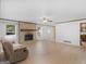 Open-concept living space with brick fireplace, laminate flooring, and view of the kitchen at 1001 Stagecoach Rd, Stockbridge, GA 30281