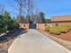 Long driveway leading to a brick home with decorative wreaths, set amidst lush landscaping and manicured bushes at 200 Magnolia Ct, Mcdonough, GA 30252