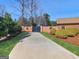 Long driveway leading to a brick home with decorative wreaths, set amidst lush landscaping and manicured bushes at 200 Magnolia Ct, Mcdonough, GA 30252