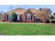 Charming single-story brick home featuring a manicured lawn and mature landscaping at 200 Magnolia Ct, Mcdonough, GA 30252
