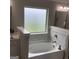 Bright bathroom with a soaking tub, tiled backsplash, and frosted window at 160 Elysian Dr, Fayetteville, GA 30214