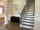 Open foyer showcases staircase with iron railing, stylish clock, and hardwood floors at 160 Elysian Dr, Fayetteville, GA 30214