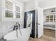 Bathroom features a modern soaking tub, marble accents, and a black-framed mirror at 319 S Mount Carmel Rd, Mcdonough, GA 30253